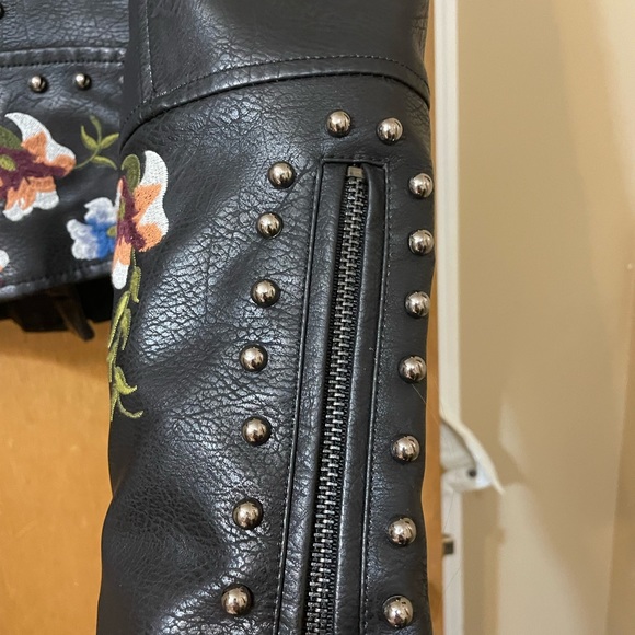Floral embroidery, stud accents, buckles on side, faux leather, zipper on arms. - Picture 5 of 8
